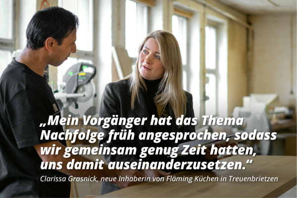 Zwei Personen stehen in einer Werkstatt oder Produktionsumgebung und unterhalten sich. Im Hintergrund sind große Fenster, Holzbalken und Arbeitsflächen sichtbar, auf denen Werkzeuge und Materialien liegen. Im Vordergrund ist ein Zitat eingeblendet. „Mein Vorgänger hat das Thema Nachfolge früh angesprochen, sodass wir gemeinsam genug Zeit hatten, uns damit auseinanderzusetzen.“ Darunter steht die Quellenangabe: „Clarissa Grasnick, neue Inhaberin von Fläming Küchen in Treuenbrietzen.